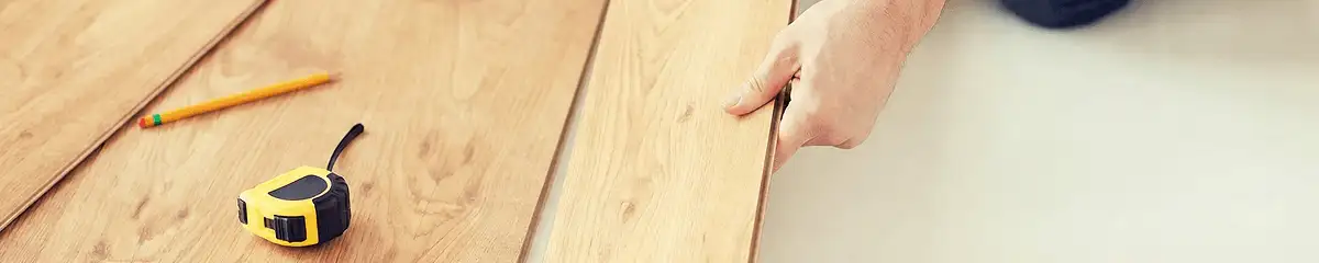 A professional installing wood flooring in Manchester, NH